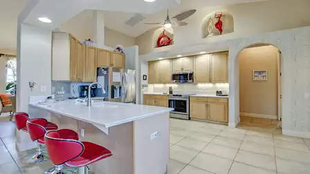 Take a seat at the beautiful kitchen counter with three top red high chairs