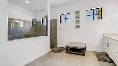 The adjoining bathroom impresses with its walk-in shower