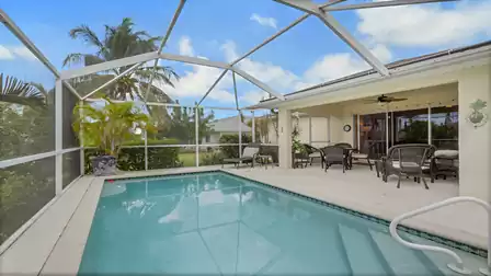 Screened pool with a spacious patio and comfortable lounge area.