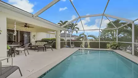 Screened pool with a cozy lounge area and spacious outdoor seating.