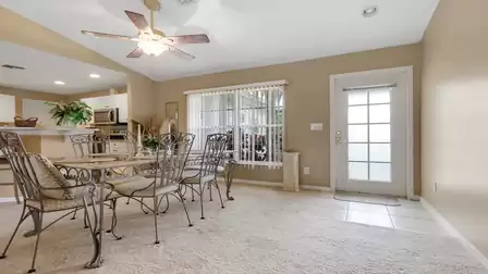 Bright dining area with an open layout to the kitchen and views of the front garden.