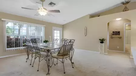 Bright dining area with a large dining table and views of the well-maintained front garden.