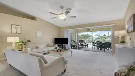 Bright living area with a cozy seating arrangement and direct access to the pool patio.