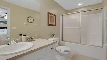 Modern bathroom with a vanity, bathtub, and shower combination.