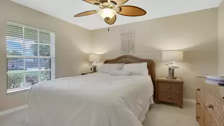 Cozy bedroom with a double bed and stylish rattan furniture.