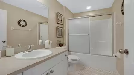 Modern bathroom with a vanity, bathtub, and shower combination.