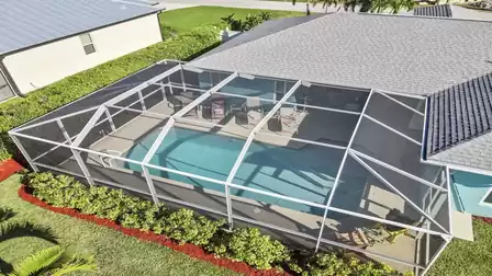 Screened pool area with comfortable sun loungers and covered patio.