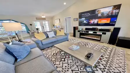A spacious, open-plan living area equipped with an impressive TV set-up