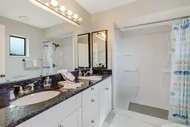 The adjoining bathroom is equipped with a walk-in shower