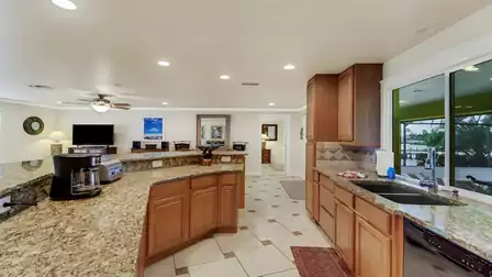 Spacious kitchen with canal view, elegant granite countertops and a practical breakfast bar - ideal for social gatherings.