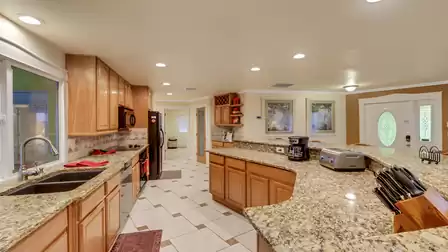 Fully equipped kitchen with high-end appliances, spacious granite countertops, and direct access to the patio - perfect for culinary evenings in your vacation home.