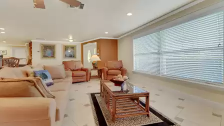 Bright living area with sofa, two leather armchairs, large window and decorative details - perfect for relaxing after a sunny day.