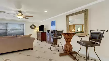 Elegant seating corner with two barstools and a tropical pineapple table - a charming highlight in Villa Cicero's spacious living area.