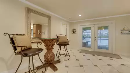 Bright entrance area with stylish pineapple table and barstools - the glass double doors open directly onto Villa Cicero’s spacious pool terrace.