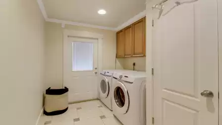 Dedicated laundry room with washer, dryer, and convenient upper cabinets for extra storage.