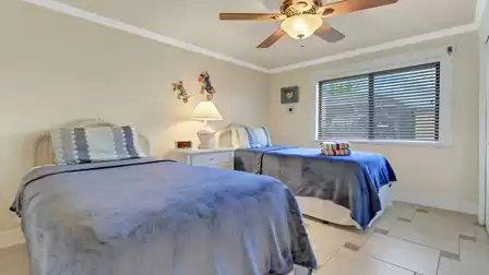 Bright bedroom with two twin beds, playful wall decor, and a cozy atmosphere.