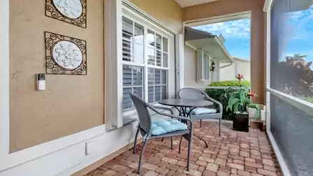 Cozy covered front patio with two chairs and a small table - ideal for enjoying your morning coffee outside.
