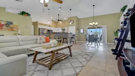 Open-concept living area with bright kitchen, breakfast bar, and adjacent dining space in modern style