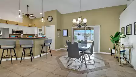 Open dining area with view of breakfast bar and access to the screened outdoor terrace