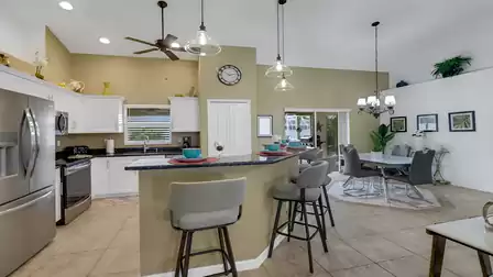 Open kitchen with breakfast bar and adjacent dining area in stylish setting