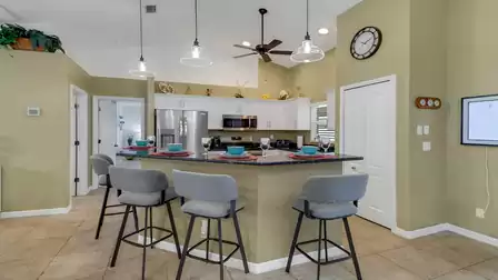 Inviting breakfast bar with four cushioned stools and a modern kitchen in the background