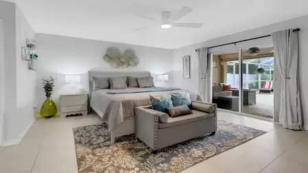Modern bedroom with king-size bed, elegant bench and direct access to the screened-in terrace