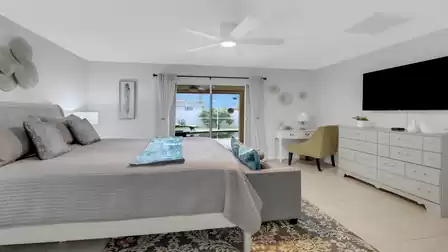 Bedroom with king-size bed, dresser, writing desk and direct view of the screened-in patio
