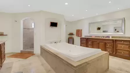 Elegant bathroom with large whirlpool tub, double vanity, and walk-in rain shower.