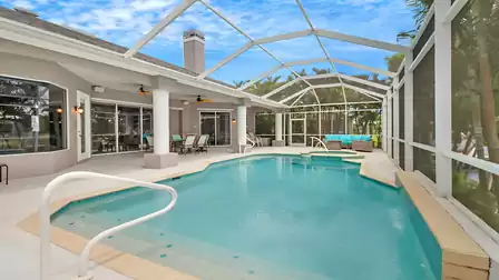 Pool area with covered terrace, dining area and lounge corner in the background.