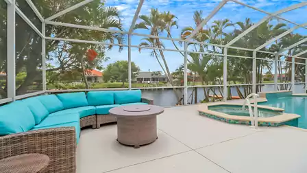 Cozy lounge with turquoise cushions next to the hot tub and canal view.
