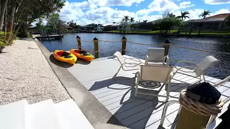 Close-up view of the dock with two yellow kayaks and four chairs for relaxing
