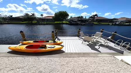 Two yellow kayaks on the dock with calm water surface in the background