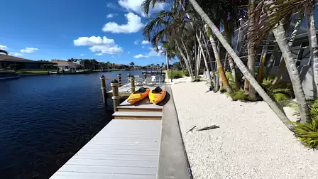 View along the canal with palm trees, dock and kayaks - pure tropical atmosphere