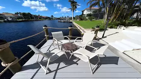 Seating area with five chairs on the dock overlooking the canal of Villa Lavinia in Cape Coral