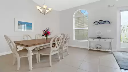 Dining area of Villa Lavinia with large wooden table and six elegant chairs