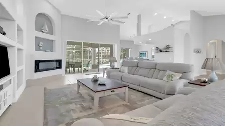 Spacious living room with two comfortable sofas, coffee table, and direct view of the pool and patio.
