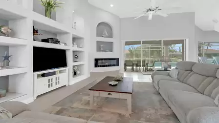 Living area with TV, stylish décor, and direct access to the patio.