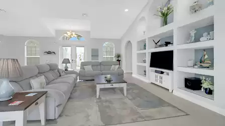 View into the open living area with two sofas, large windows, and charming details.