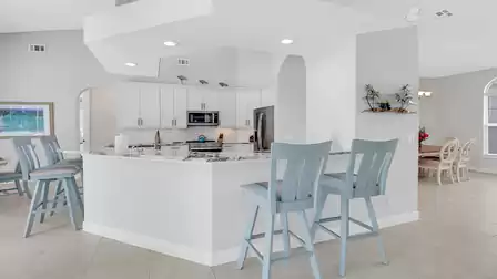 View from living room into the the kitchen with open shelving and decorative elements.
