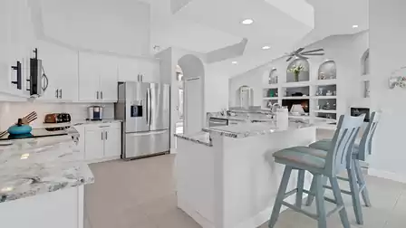 Modern kitchen with bright cabinets, stainless steel appliances and granite countertops, adjacent to the living area.