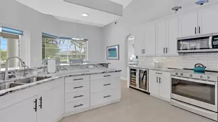 Spacious, open-plan kitchen with bar area and ocean view through the windows.