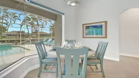 Breakfast area with glass front offering a view of the terrace and pool area.