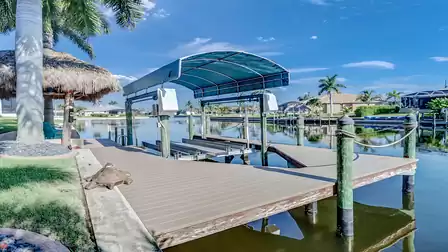 Spacious boat dock with palm trees and water views, decorated with a turtle sculpture.