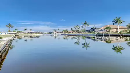 Beautiful view across the calm canal with palm trees and manicured properties - pure Florida vibes.