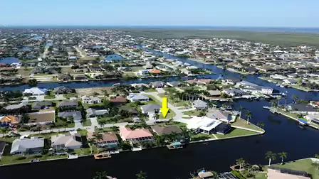 Wide aerial view of the Cape Coral neighborhood with the home’s prime waterfront location highlighted.
