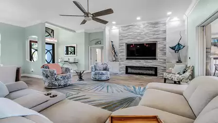 Stylishly furnished living room featuring an accent wall, built-in TV, and coastal-themed decorative elements.