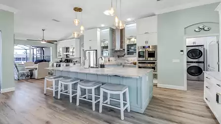 Modern kitchen with a large island, high-end appliances, and elegant lighting - ideal for cooking together.