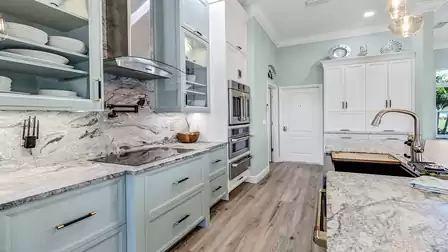 Close-up of kitchen area with glass cabinets, granite backsplash, and modern built-in appliances