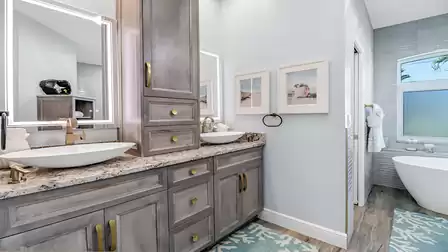 Double vanity with elegant marble countertop, LED mirrors, and stylish wood cabinetry in the master bathroom.
