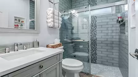 Modern bathroom with glass shower and turquoise wall tiles